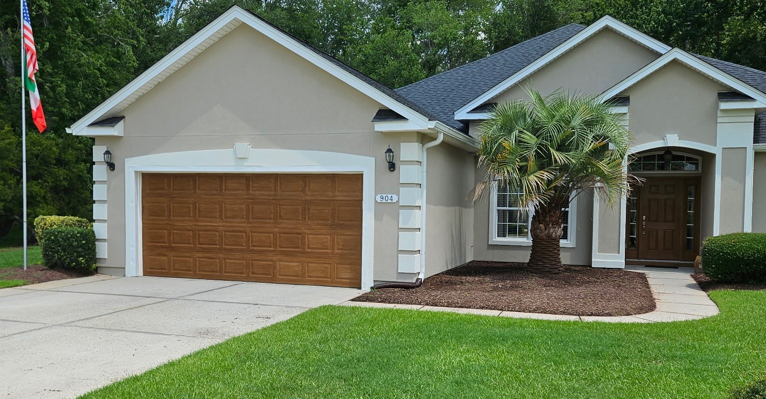 A home with a freshly finished wood-grain garage door and front door
